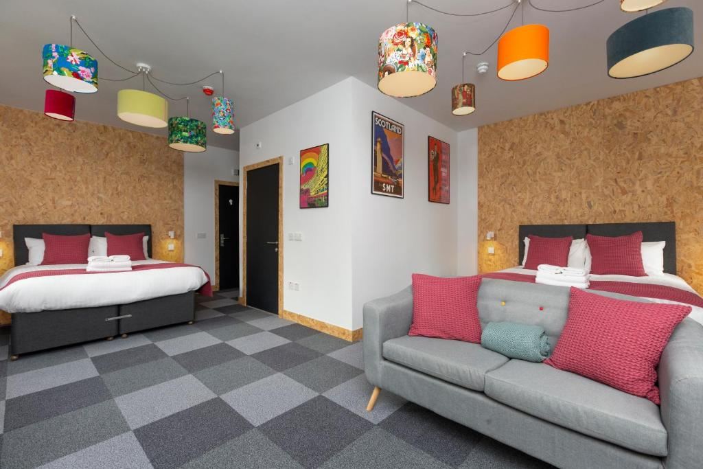 On The Walk Edinburgh guest room with two comfortable beds, a sofa and colourful lamps